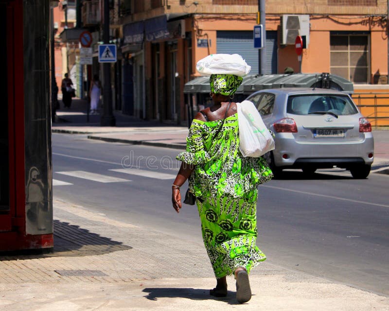 Carthagène, Murcie, Espagne - 1er août 2018 : Une femme afro-antillaise dans l'habillement africain traditionnel vert clair, marc image libre de droits Carthagène, Murcie, Espagne - 1er août 2018 : Une femme afro-antillaise dans l'habillement africain traditionnel vert clair, marc image libre de droits