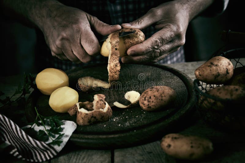 Cartofi pentru cojire de tip masculin pentru culturi în bucătărie stock image