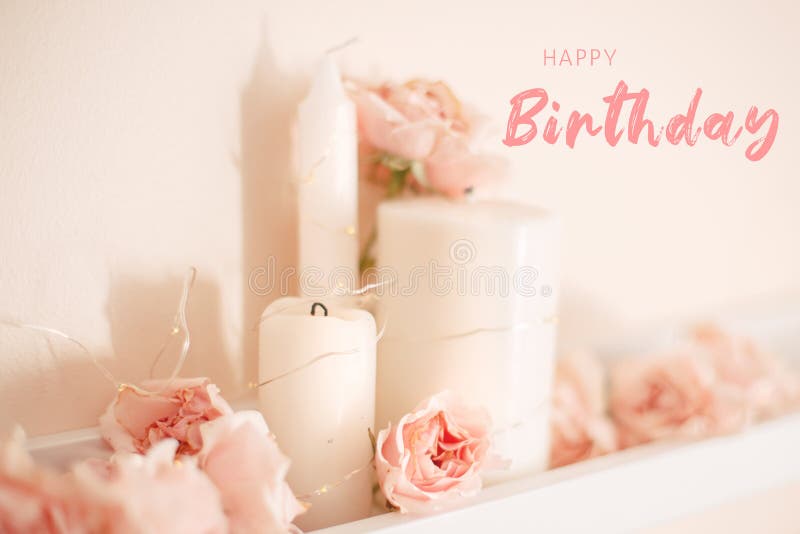 Happy Birthday card with greeting text. Decoration of  room for birthday celebration. Closeup of tender light pastel pink roses and white candles on shelf for themed party. Happy Birthday card with greeting text. Decoration of  room for birthday celebration. Closeup of tender light pastel pink roses and white candles on shelf for themed party