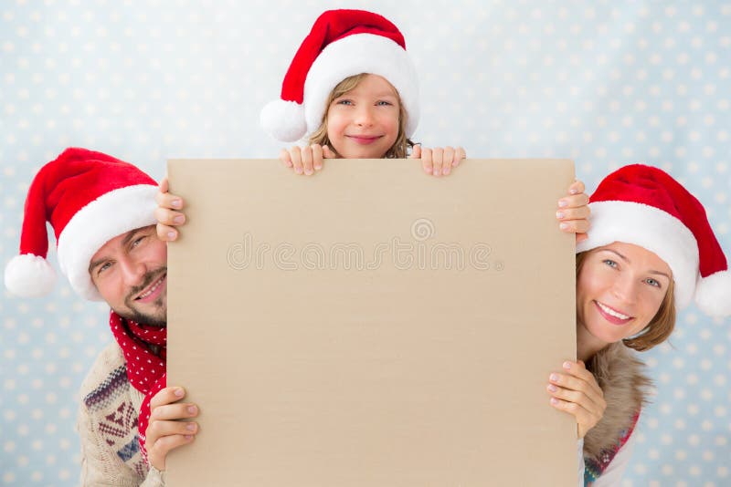 Cartolina di Natale felice della tenuta della famiglia immagine stock Cartolina di Natale felice della tenuta della famiglia immagine stock