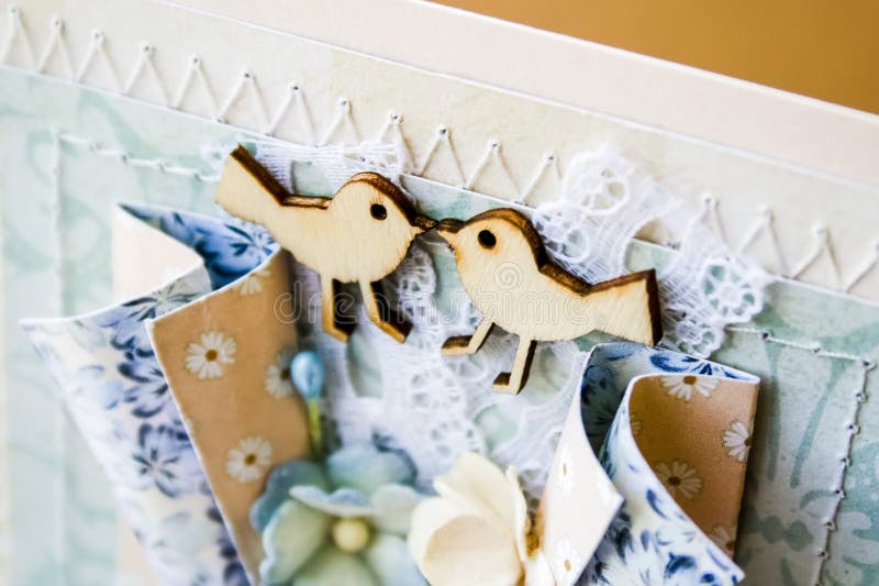 Cartolina fatta a mano nello stile scrapbooking Due uccelli di legno che se esaminano, pizzo, mano cucente, fiori di carta fotografia stock libera da diritti Cartolina fatta a mano nello stile scrapbooking Due uccelli di legno che se esaminano, pizzo, mano cucente, fiori di carta fotografia stock libera da diritti