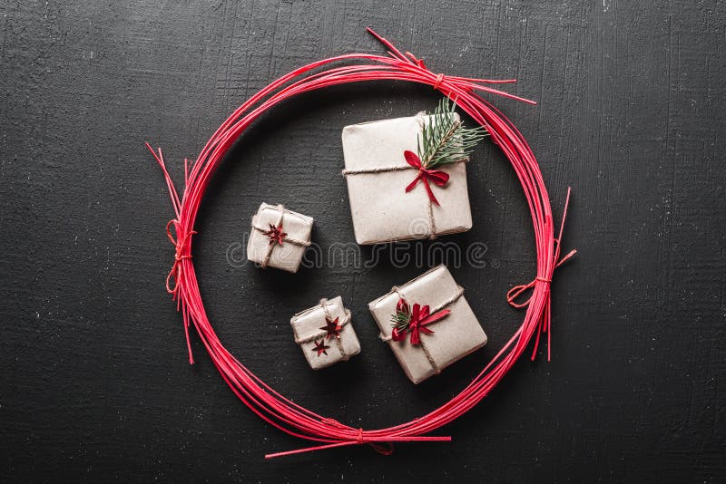 Cartoline d'auguri di giorno del ` s del nuovo anno e di Natale, vacanze invernali in un cerchio rosso, regali neri del fondo fotografia stock libera da diritti Cartoline d'auguri di giorno del ` s del nuovo anno e di Natale, vacanze invernali in un cerchio rosso, regali neri del fondo fotografia stock libera da diritti