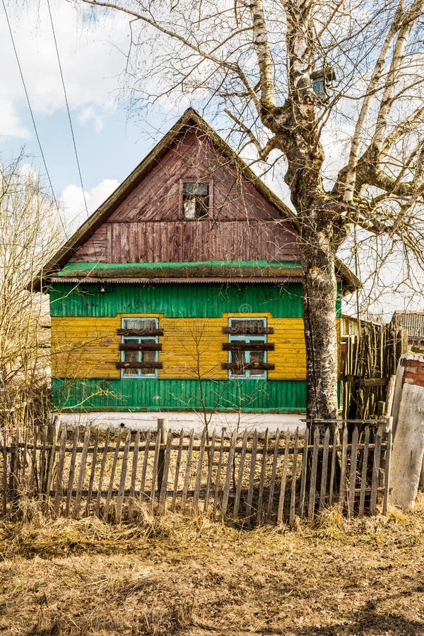 Casa abandonada de madera vieja, casa de campo verde amarilla con las ventanas ascendentes subidas imagenes de archivo Casa abandonada de madera vieja, casa de campo verde amarilla con las ventanas ascendentes subidas imagenes de archivo
