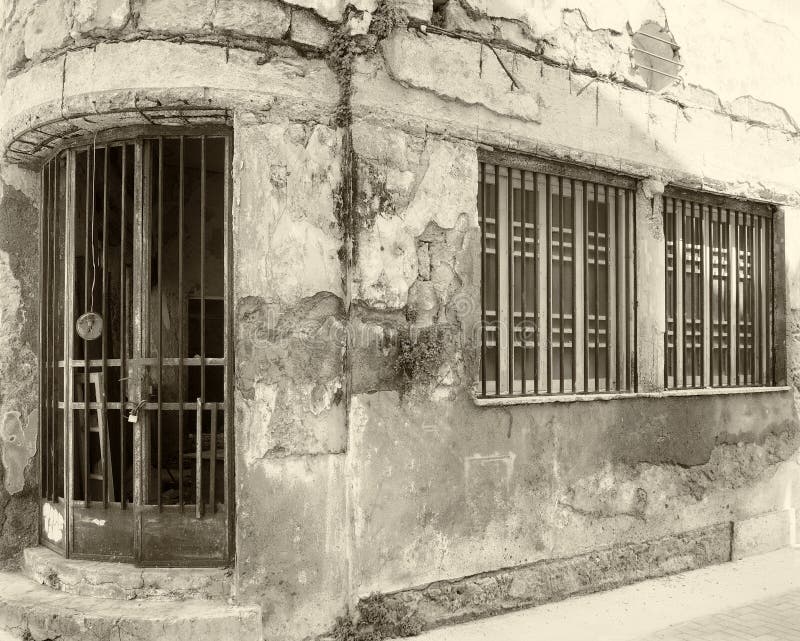 Casa comercial abandonada vieja de la sepia del vintage en una esquina con las paredes que desmenuzan y las barras de hierro que fotos de archivo libres de regalías Casa comercial abandonada vieja de la sepia del vintage en una esquina con las paredes que desmenuzan y las barras de hierro que fotos de archivo libres de regalías