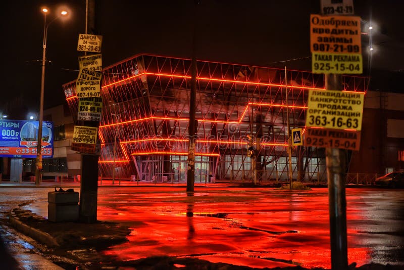 Casa con la iluminación y la reflexión rojas en el asfalto af mojado fotos de archivo Casa con la iluminación y la reflexión rojas en el asfalto af mojado fotos de archivo