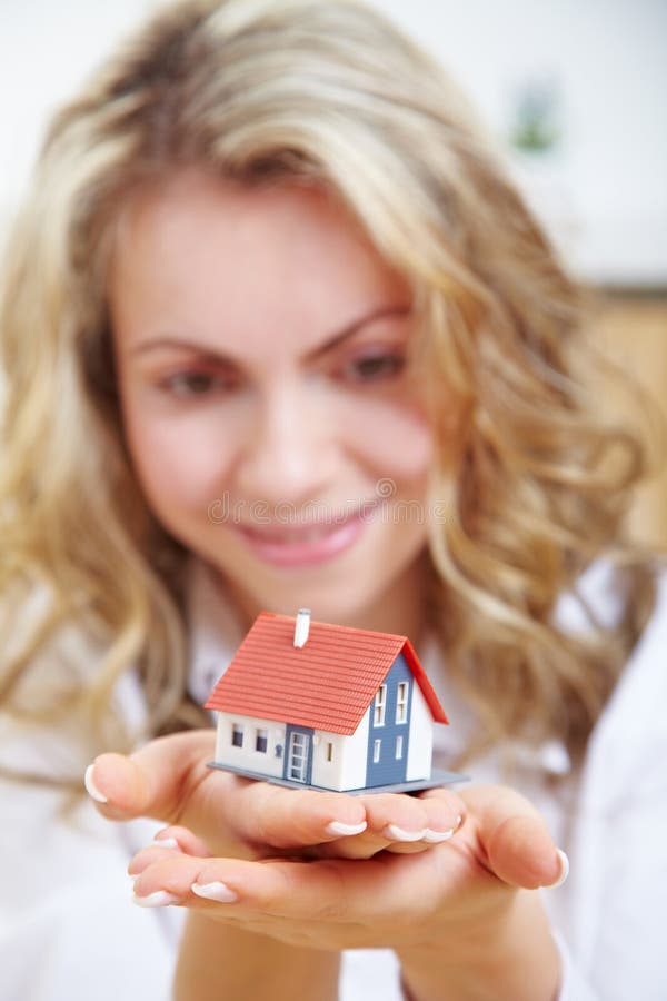 Mulher a segurar uma casa nas mãos fotografia de stock royalty free