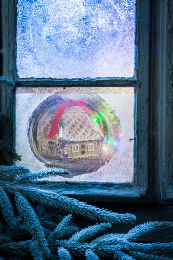 Casa de campo adorável do pão-de-espécie para o Natal na janela congelada fotografia de stock Casa de campo adorável do pão-de-espécie para o Natal na janela congelada fotografia de stock