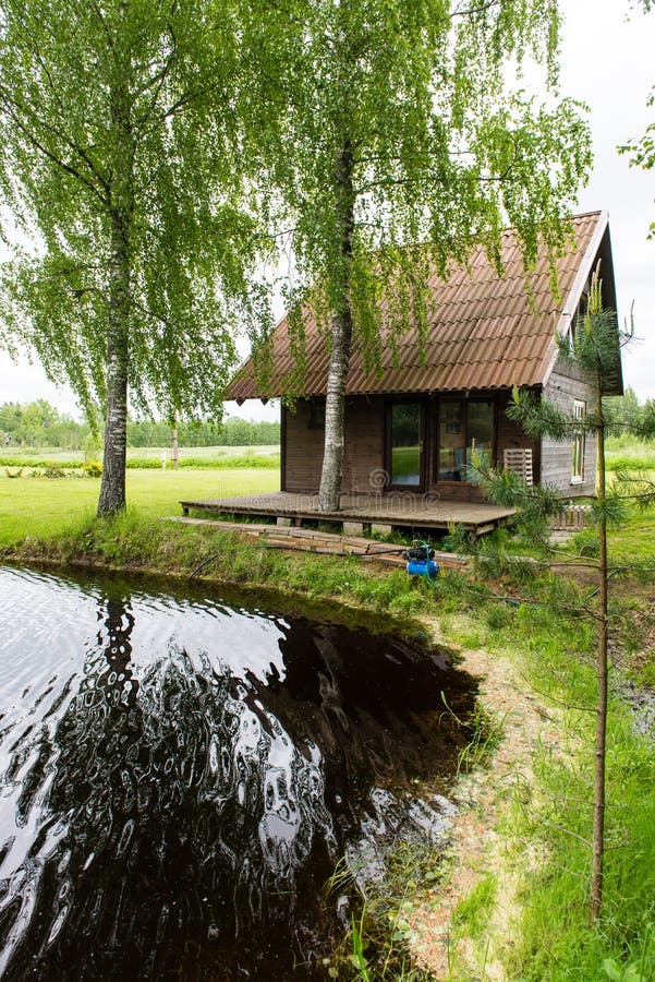 Casa de campo com lagoa e carvalhos com lagoa fotografia de stock