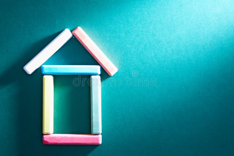 Close-up of colorful pieces of chalk put in form of house on blackboard. Close-up of colorful pieces of chalk put in form of house on blackboard
