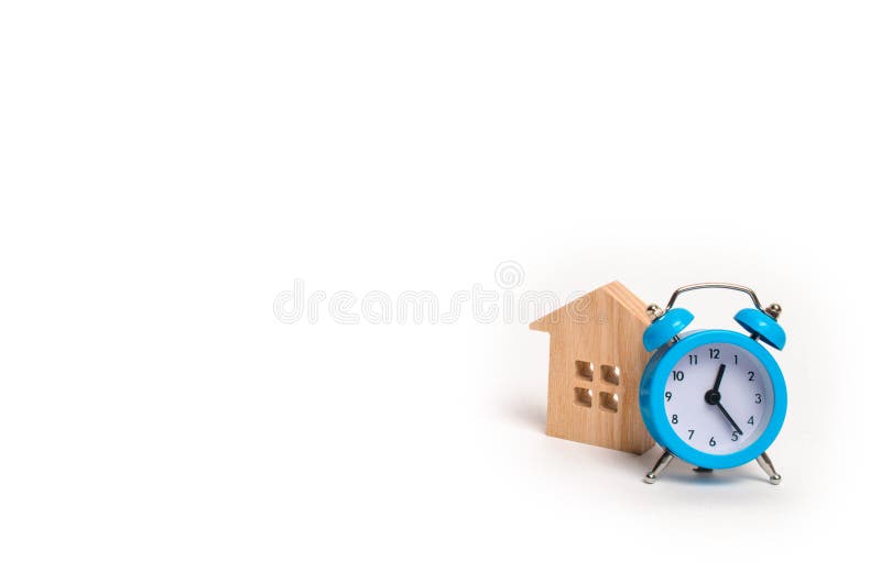 Casa de madeira e despertador azul em um fundo branco O conceito do aluguel que abriga a revista mensal e de hora em hora Acco di fotografia de stock royalty free Casa de madeira e despertador azul em um fundo branco O conceito do aluguel que abriga a revista mensal e de hora em hora Acco di fotografia de stock royalty free