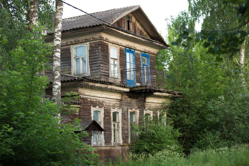 Casa de madeira velha do dois-andar na cidade provincial do russo no por do sol