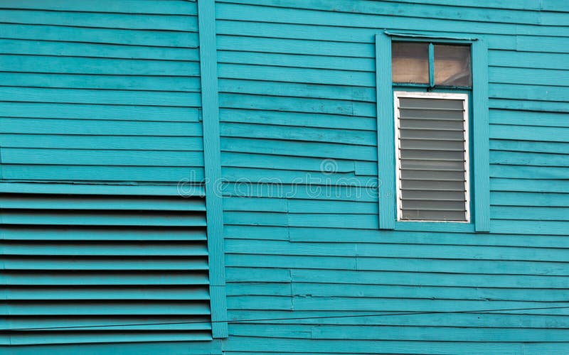 A casa de madeira velha pintou o azul brilhante com janela de vidro fotografia de stock A casa de madeira velha pintou o azul brilhante com janela de vidro fotografia de stock