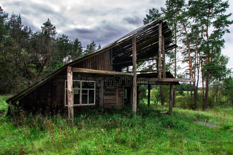 Casa de madera abandonada melancólica vieja en el bosque foto de archivo libre de regalías Casa de madera abandonada melancólica vieja en el bosque foto de archivo libre de regalías