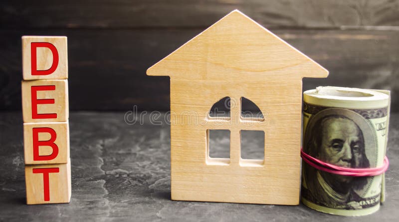 Casa de madera miniatura, dólares y la inscripción ‘deuda ‘ Propiedades inmobiliarias, ahorros caseros, concepto del mercado de l