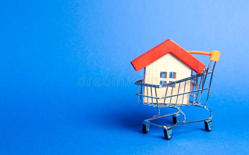 Wooden house in a Supermarket trading cart. The concept of buying a house or apartment. Affordable housing. Profitable and cheap loans for real estate. Buying a home. Mortgage and loan. Place for text. Wooden house in a Supermarket trading cart. The concept of buying a house or apartment. Affordable housing. Profitable and cheap loans for real estate. Buying a home. Mortgage and loan. Place for text