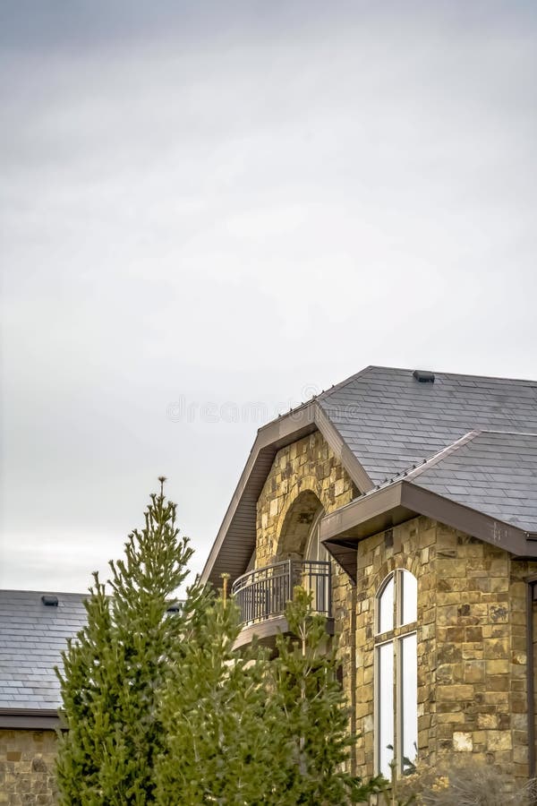 Casa di pietra con il balcone del semicerchio e giro quarto con la finestra estesa della gamba immagini stock libere da diritti Casa di pietra con il balcone del semicerchio e giro quarto con la finestra estesa della gamba immagini stock libere da diritti