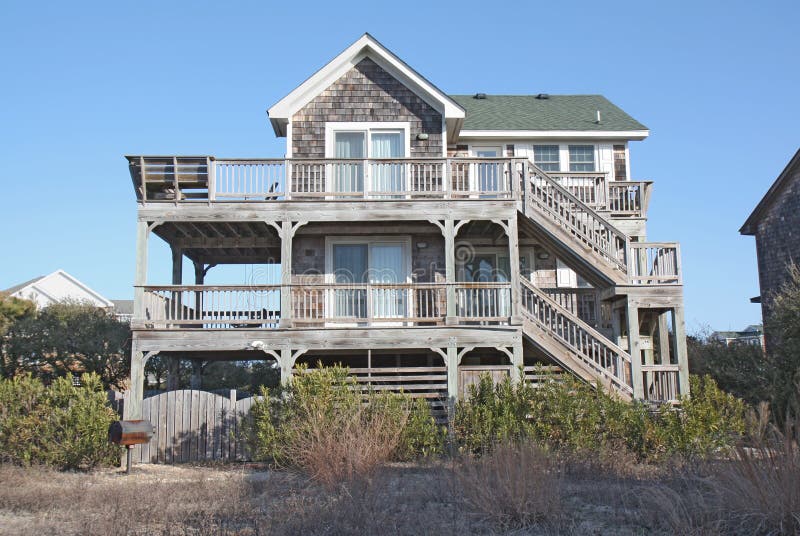 A beach house on the Outer Banks at Nags Head, North Carolina, against a bright blue sky. A beach house on the Outer Banks at Nags Head, North Carolina, against a bright blue sky