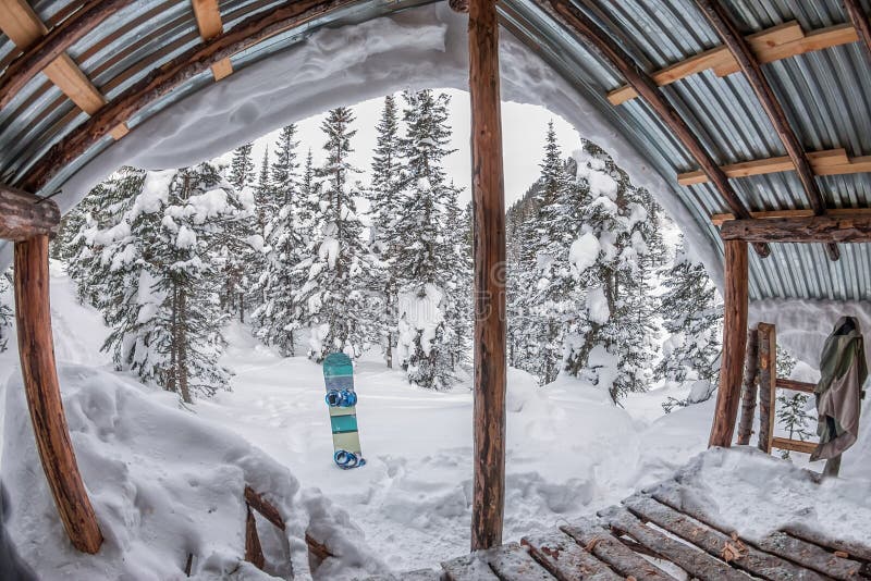Casa do patamar, chalé na floresta do inverno com neve nas montanhas e imagem de stock Casa do patamar, chalé na floresta do inverno com neve nas montanhas e imagem de stock