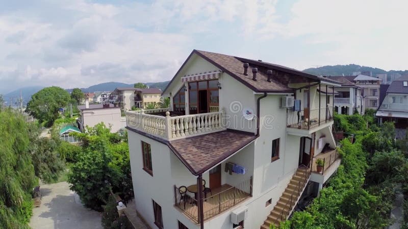 Casa entre plantas en ciudad costera en verano almacen de metraje de vídeo