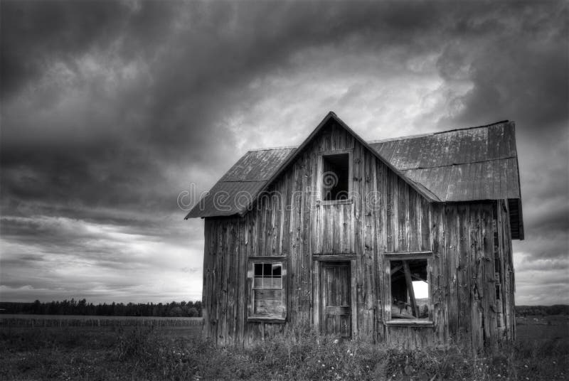Casa frecuentada abandonada de la granja con el cielo tempestuoso fotografía de archivo libre de regalías Casa frecuentada abandonada de la granja con el cielo tempestuoso fotografía de archivo libre de regalías