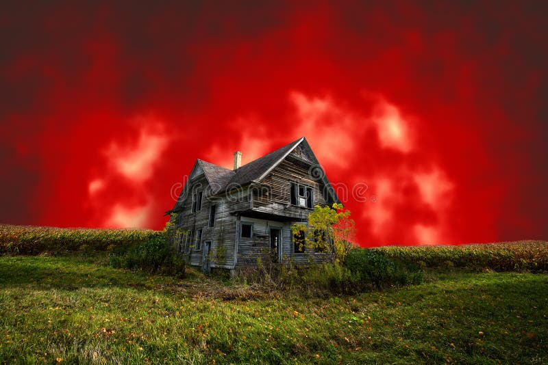 Casa frecuentada asustadiza de Halloween con el cielo rojo malvado