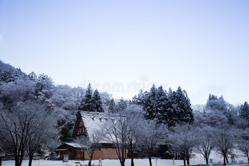 A photograph of a traditional Japan Gassho style or Gassho-zukuri with its steep roof that allows snow to fall down easily to the ground. Taken in the winter morning at Shirakawa-go after a snowfall the night before. the photograph also depicts the mountain range in the background. A photograph of a traditional Japan Gassho style or Gassho-zukuri with its steep roof that allows snow to fall down easily to the ground. Taken in the winter morning at Shirakawa-go after a snowfall the night before. the photograph also depicts the mountain range in the background