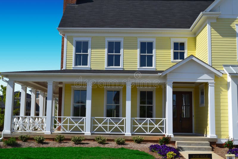 Casa gialla di stile della Nuova Inghilterra con il portico