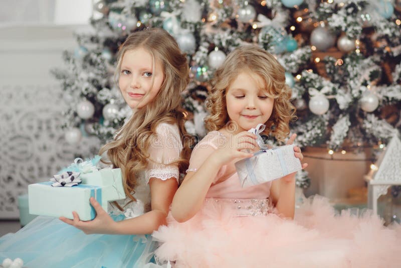 Casa magica aperta del regalo della sorella felice dei bambini vicino all'albero in vestito Buon Natale immagine stock