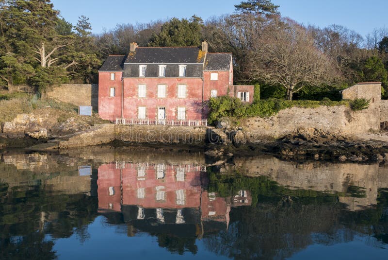 Casa no Ile-auxiliar-Moines Golfo de Morbihan com reflexões em t fotografia de stock Casa no Ile-auxiliar-Moines Golfo de Morbihan com reflexões em t fotografia de stock