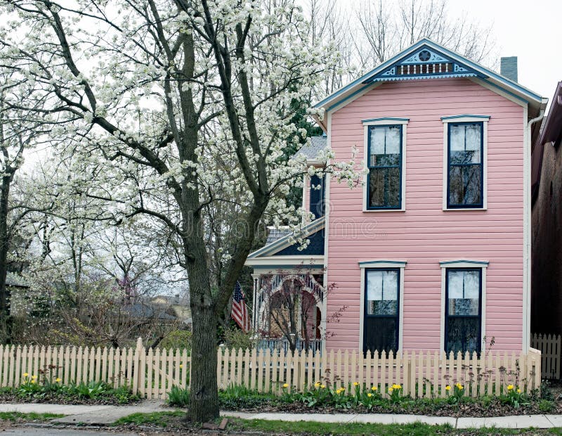 Pequeña Casa Amarilla Exterior Con La Valla De Estacas Blanca Imagen de