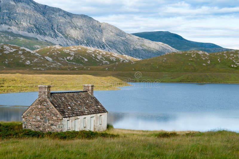 Casa solitaria en el valle con montañas foto de archivo libre de regalías