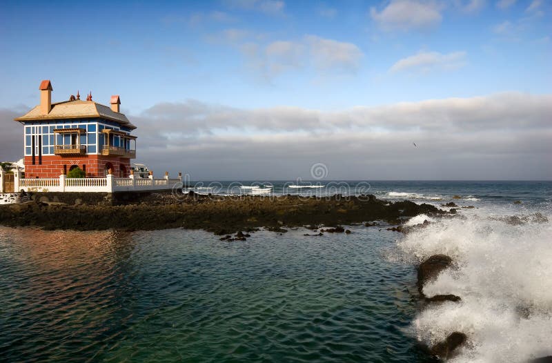 Casa vermelha e azul na borda do mar. imagem de stock Casa vermelha e azul na borda do mar. imagem de stock