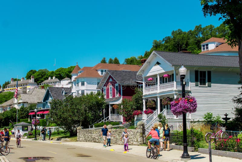 Casa vitoriano que alinha as ruas da ilha de Mackinac perto da baixa como os turistas andam perto no verão foto de stock Casa vitoriano que alinha as ruas da ilha de Mackinac perto da baixa como os turistas andam perto no verão foto de stock