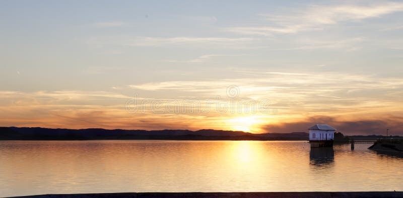 Casa solitaria y lago imagenes de archivo