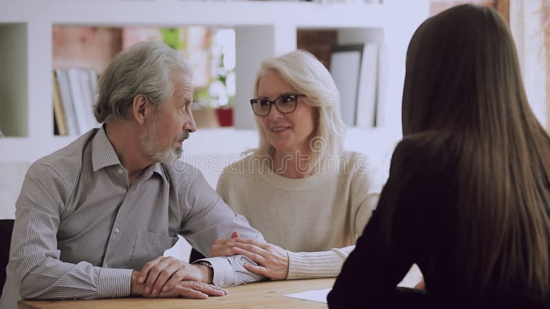 Casal de família de meia-idade feliz encontrando uma agente imobiliária feminina.