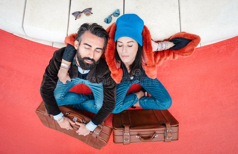Hipster couple having rest at trip on the road - Wanderlust concept with relaxed boyfriend and girlfriend in love on tender hug at travel time with vintage leather case. Hipster couple having rest at trip on the road - Wanderlust concept with relaxed boyfriend and girlfriend in love on tender hug at travel time with vintage leather case