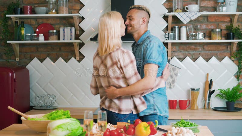 Casal feliz, apaixonado, dançando na cozinha em casa e se divertindo