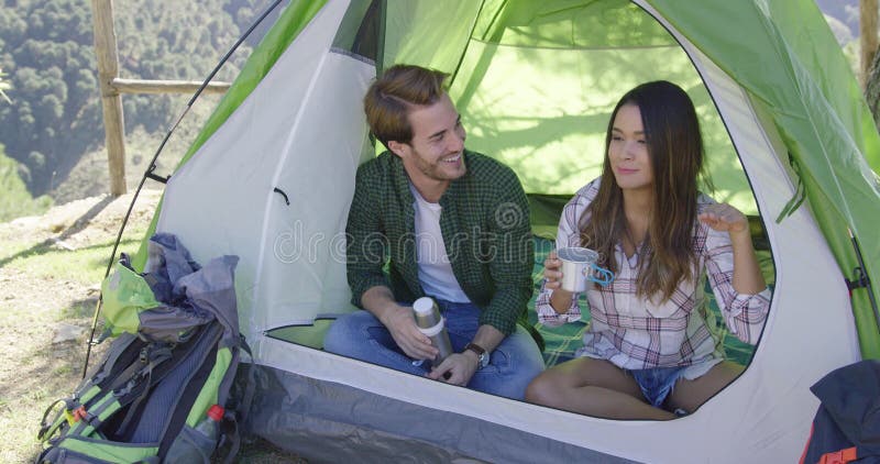 Casal feliz descansando numa tenda