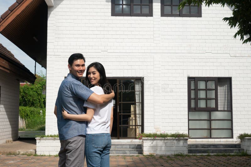 Casal feliz em frente à nova casa, em se mudar no dia e começar uma nova família. conceito de proprietário e deslocalização