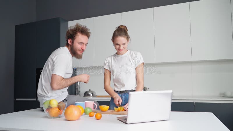 Casal recém-casado mudou-se para uma nova casa. tendo uma chamada em vídeo usando um casal jovem laptop conversando com seus pais