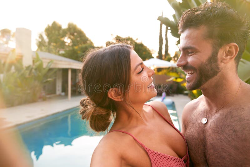 Casal romântico na festa da piscina de verão tomando selfie no celular