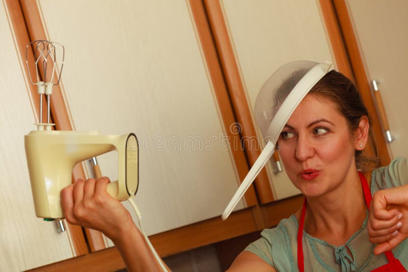 Casalinga con il miscelatore divertendosi nella cucina fotografia stock libera da diritti Casalinga con il miscelatore divertendosi nella cucina fotografia stock libera da diritti