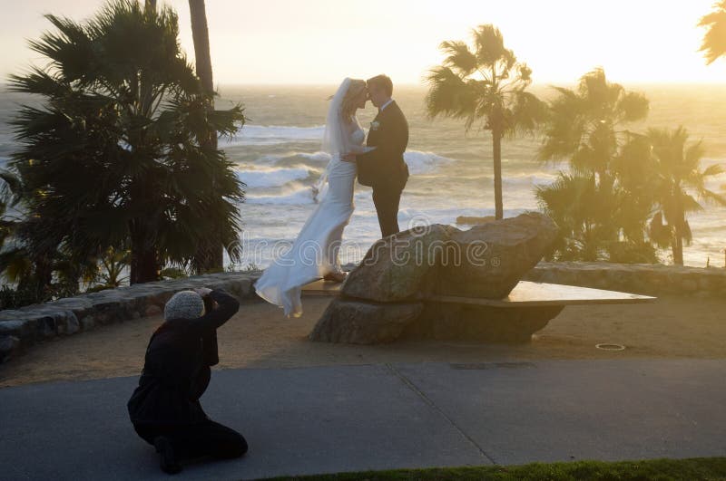 Image shows a couple having their wedding picture taken at sunset in Heisler Park, Laguna Beach, California. This event is taking place during the tail end of a winter storm. Wedding permits are issued by the city for a two hour period for the use of a designated City beach or park. Image shows a couple having their wedding picture taken at sunset in Heisler Park, Laguna Beach, California. This event is taking place during the tail end of a winter storm. Wedding permits are issued by the city for a two hour period for the use of a designated City beach or park.