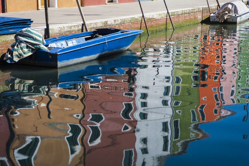 Colorful houses and a boat, with reflections in the canal, Burano, Italy, near Venice. Colorful houses and a boat, with reflections in the canal, Burano, Italy, near Venice