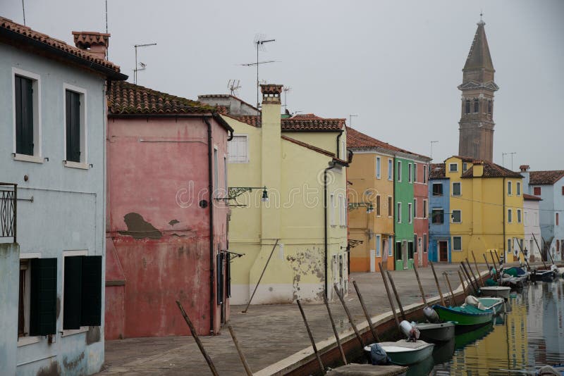 Casas coloridas na ilha de Burano perto de Veneza, Itália no canal da água com barcos fotografia de stock royalty free Casas coloridas na ilha de Burano perto de Veneza, Itália no canal da água com barcos fotografia de stock royalty free