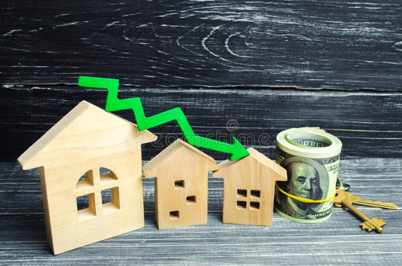 Casas con la flecha verde abajo Una disminución en precios de la propiedad rendimiento energético bajo, interés descendente en la imagenes de archivo Casas con la flecha verde abajo Una disminución en precios de la propiedad rendimiento energético bajo, interés descendente en la imagenes de archivo
