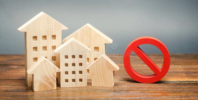 Casas de madeira e sinal de proibição Habitação inacessível e dispendiosa Restrições e proibição da construção de edifícios foto de stock royalty free Casas de madeira e sinal de proibição Habitação inacessível e dispendiosa Restrições e proibição da construção de edifícios foto de stock royalty free