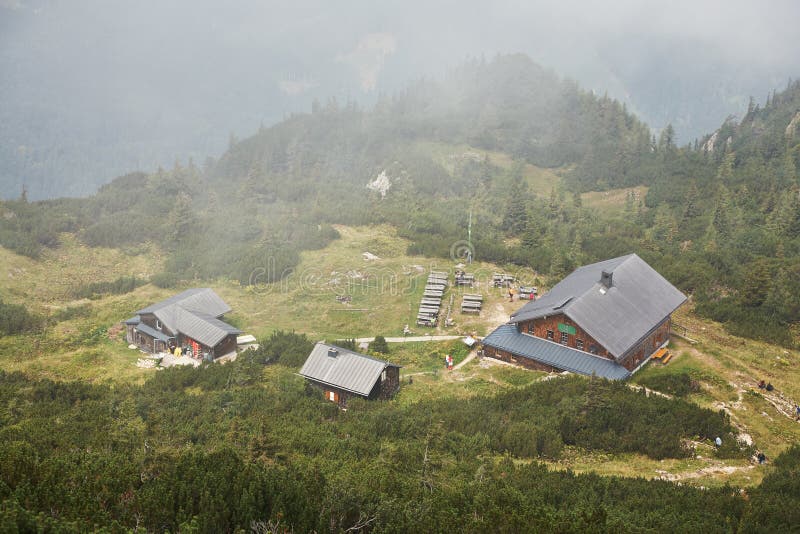 Casas de madera viejas en un valle escénico de la montaña en la niebla Refugio que camina turístico fotografía de archivo libre de regalías Casas de madera viejas en un valle escénico de la montaña en la niebla Refugio que camina turístico fotografía de archivo libre de regalías