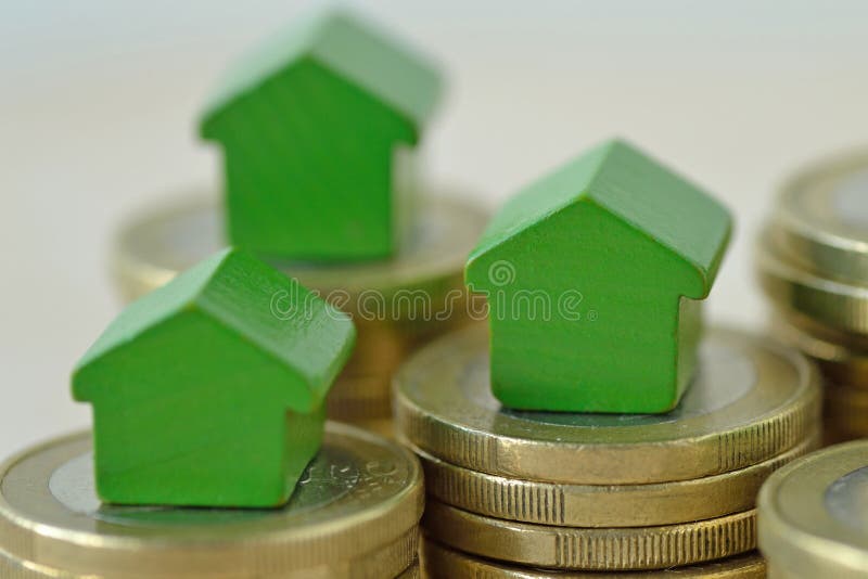 Casas diminutas verdes nas pilhas da moeda - conceito dos organismos de investimento imobiliário, da hipoteca, do seguro da casa foto de stock Casas diminutas verdes nas pilhas da moeda - conceito dos organismos de investimento imobiliário, da hipoteca, do seguro da casa foto de stock