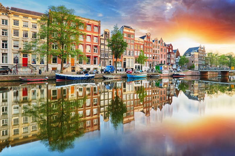 Casas en las reflexiones de la puesta del sol, Países Bajos, panor del canal de Amsterdam